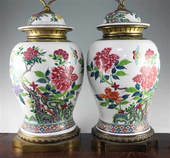 A pair of large Chinese famille rose baluster jars and covers, late 19th / early 20th century, 80.5cm to top of brass fittings